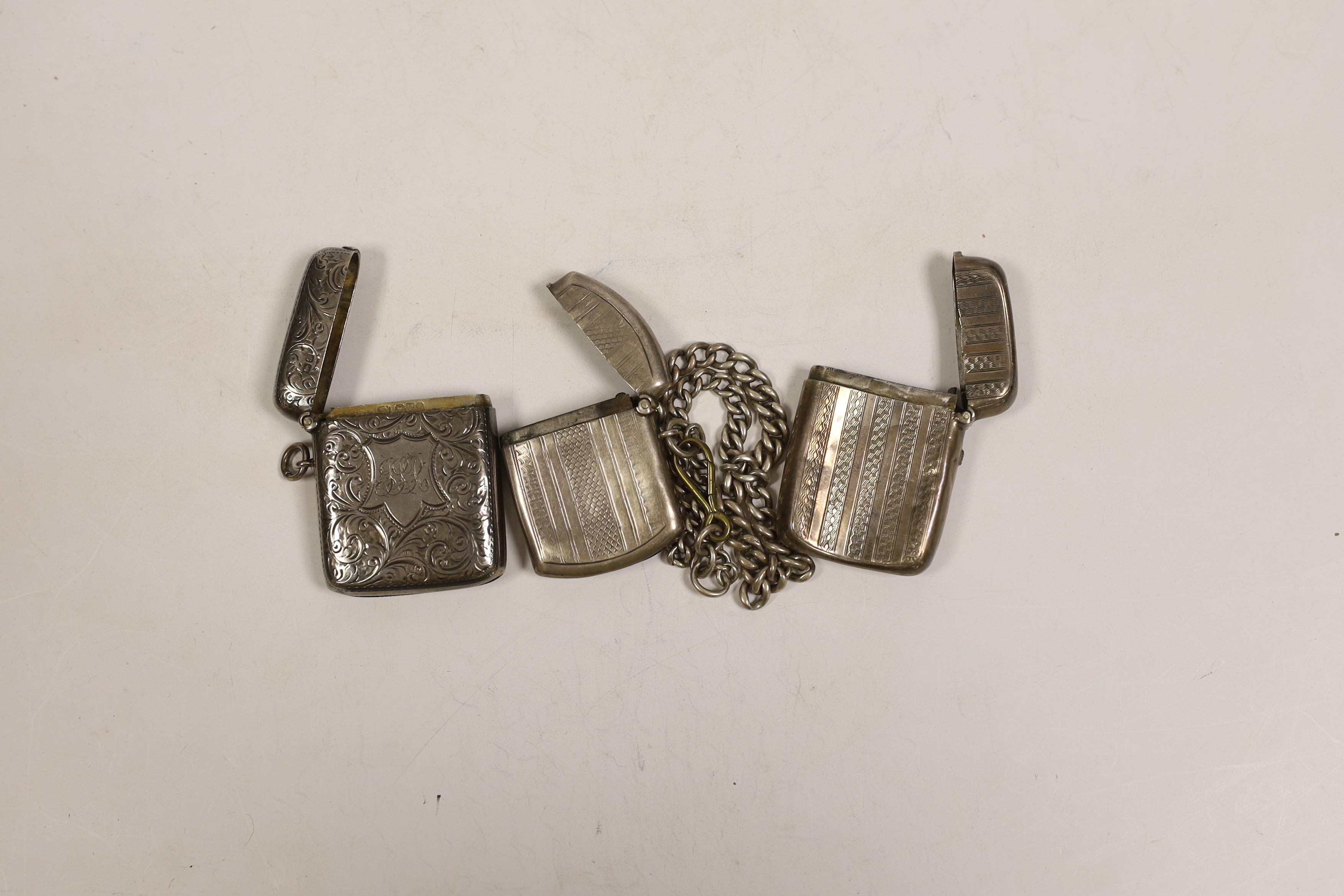 Three various silver vesta cases, together with a silver albert.